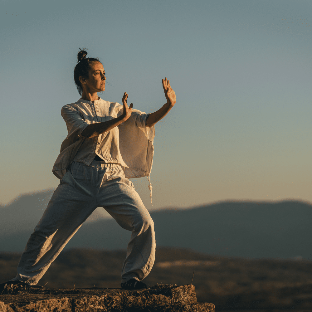 Mujer practicando Chi Kung en un entorno natural, promoviendo el bienestar integral y la armonía energética.